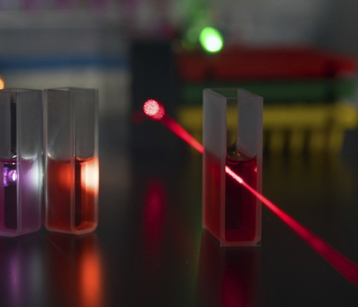 laser beam directed through red sample