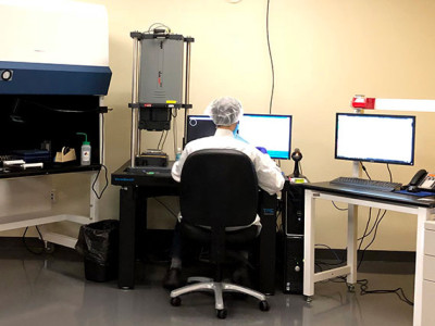 technician sitting at inspection station testing optical flatness